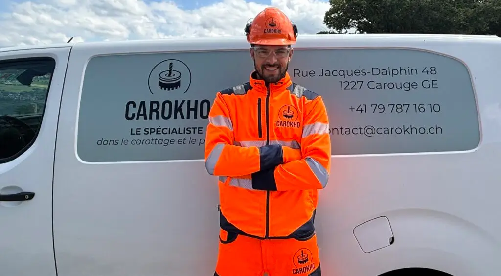 Employé Carokho réalisant un carottage béton à Genève devant un camion floqué Carokho