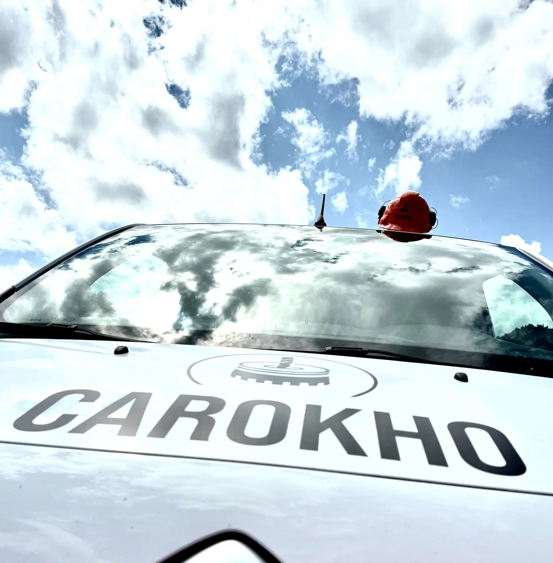 Capot du camion Carokho floqué avec un casque de chantier posé dessus, symbole des services de carottage béton à Genève